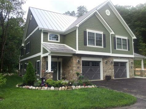 white house with green metal roof|green roof with grey siding.